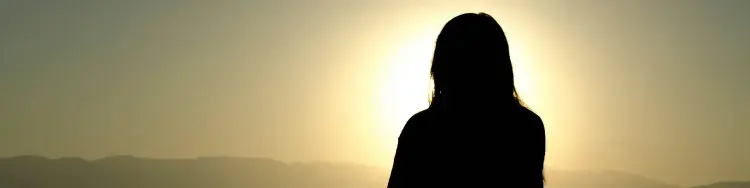 una mujer sentada viendo hacie el sol